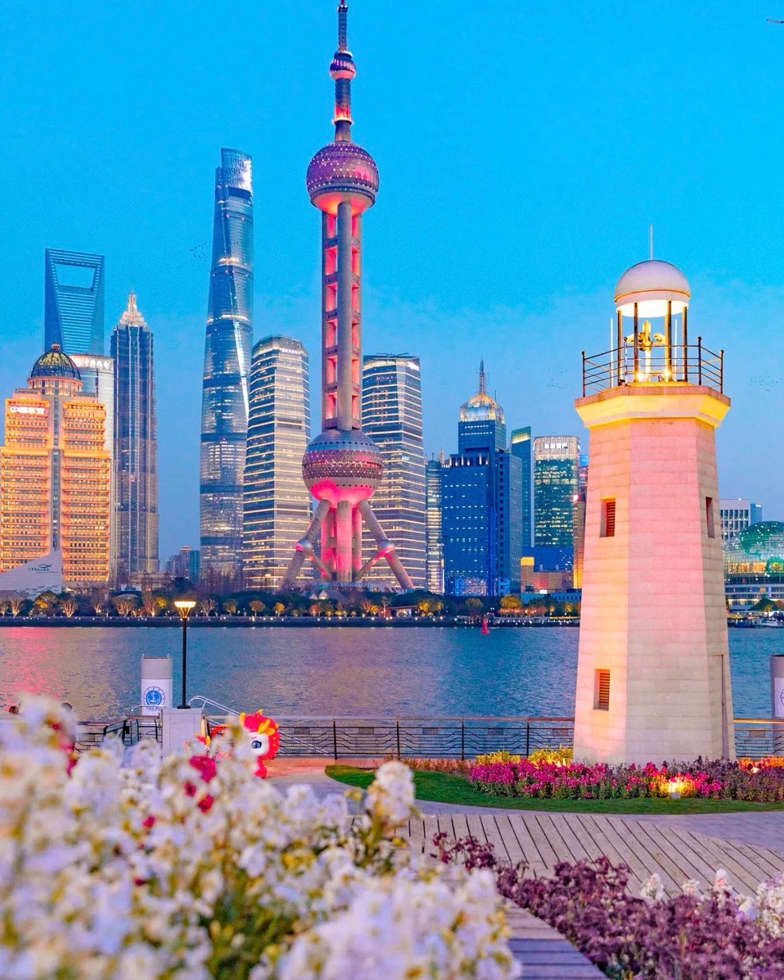 Los rascacielos de Pudong iluminados al anochecer, vistos desde la otra orilla del río Huangpu